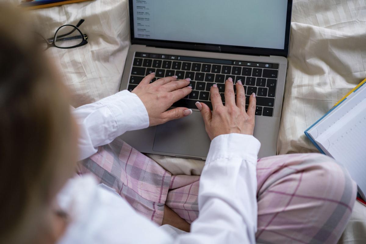 Person in bed working on a laptop