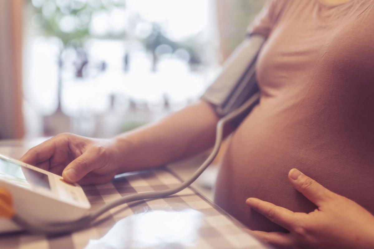 Pregnant person checking blood pressure at home