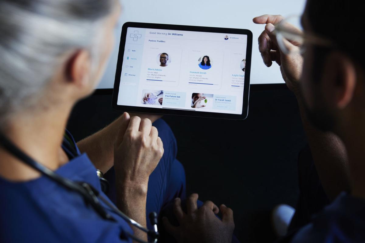 Two doctors looking at patient data on digital tablet 