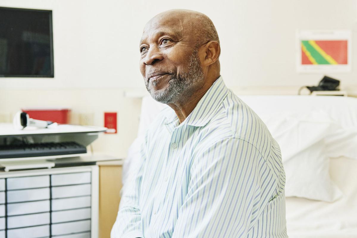 Senior patient sitting on bed in hospital room