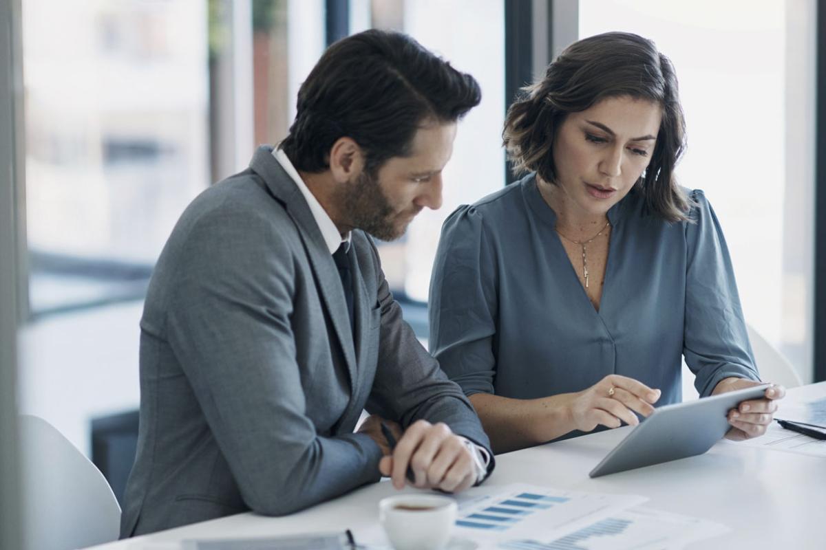 Two people reviewing data and information on a tablet
