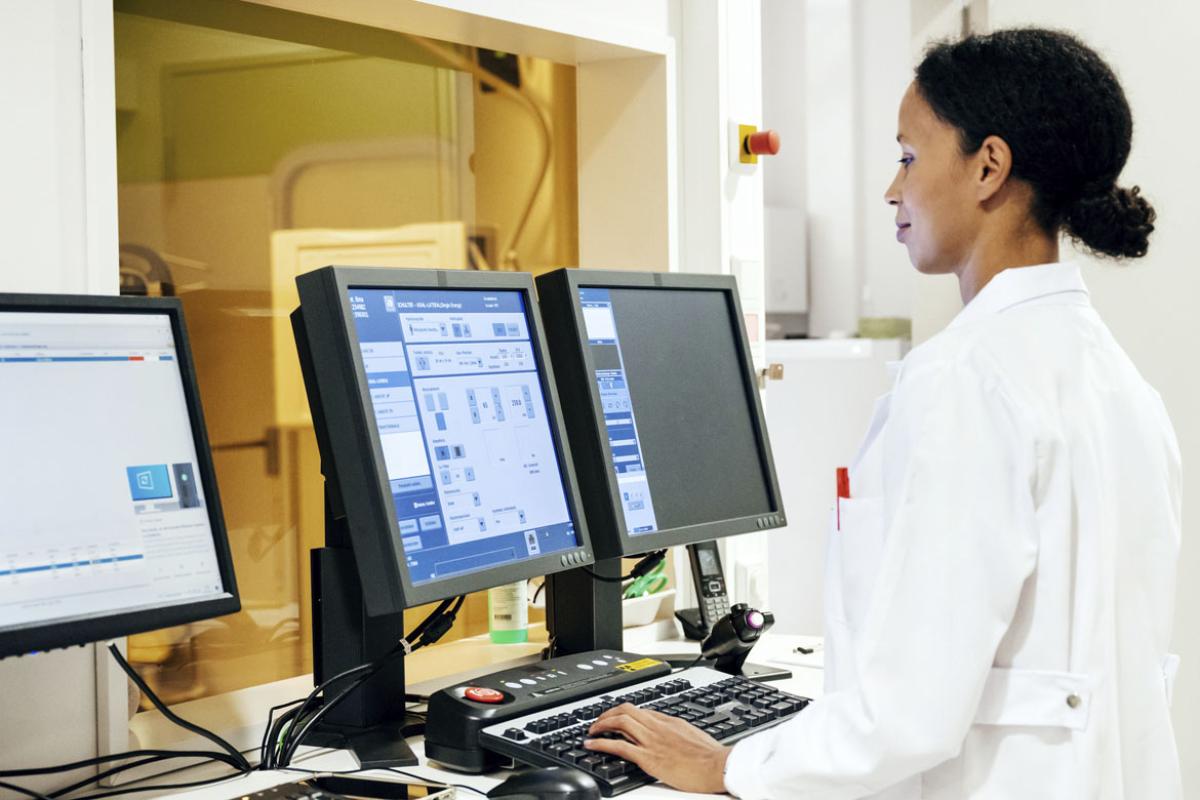 A doctor standing while using a computer