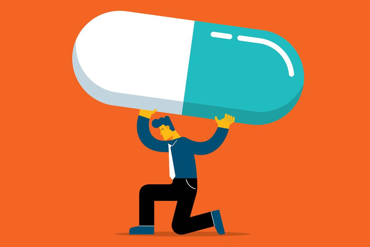 Crouching figure holding up a giant pill