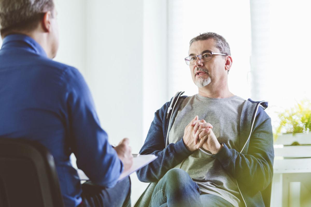 Mature patient talking with psychotherapist in an office