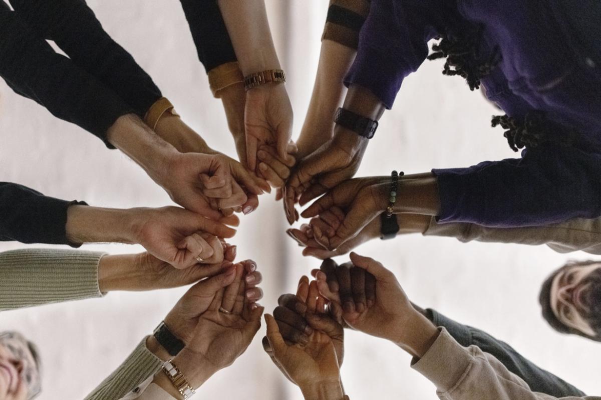 Hands coming together in the middle of a group circle