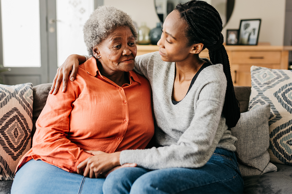 Caregiver comforts elderly woman