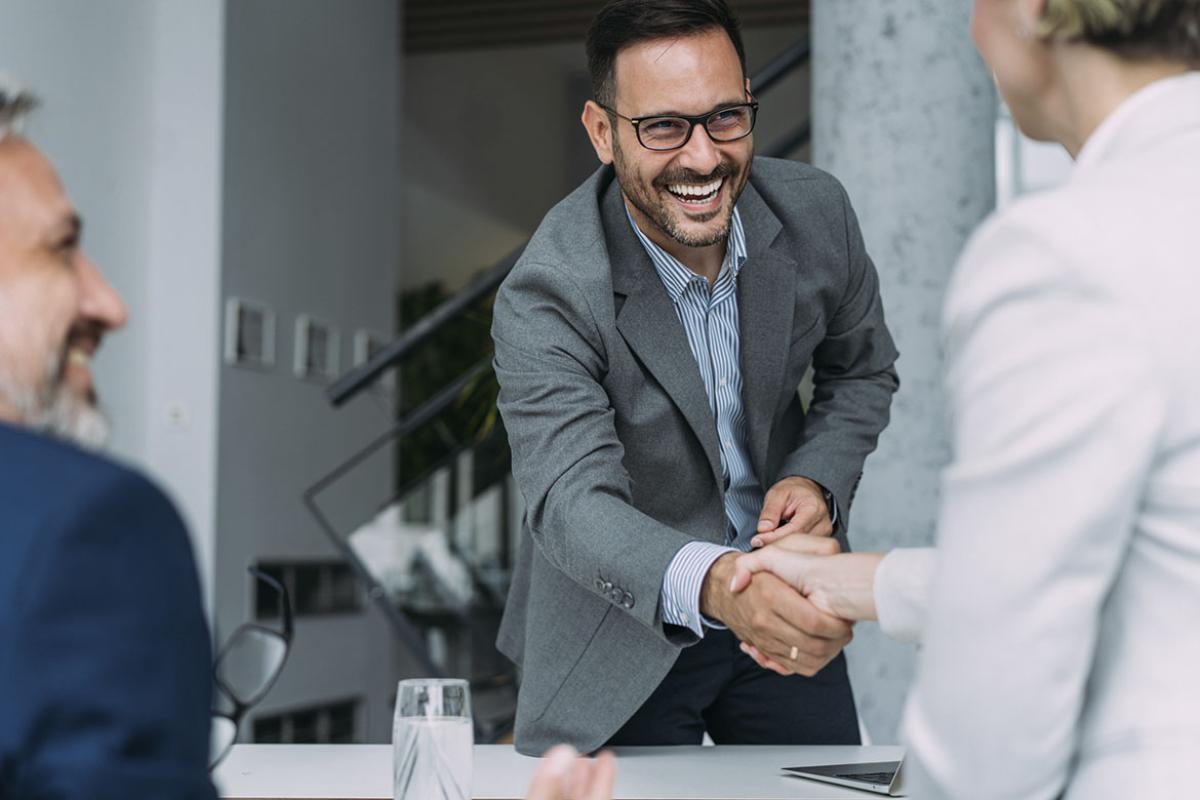 People handshaking across the table during a meeting 