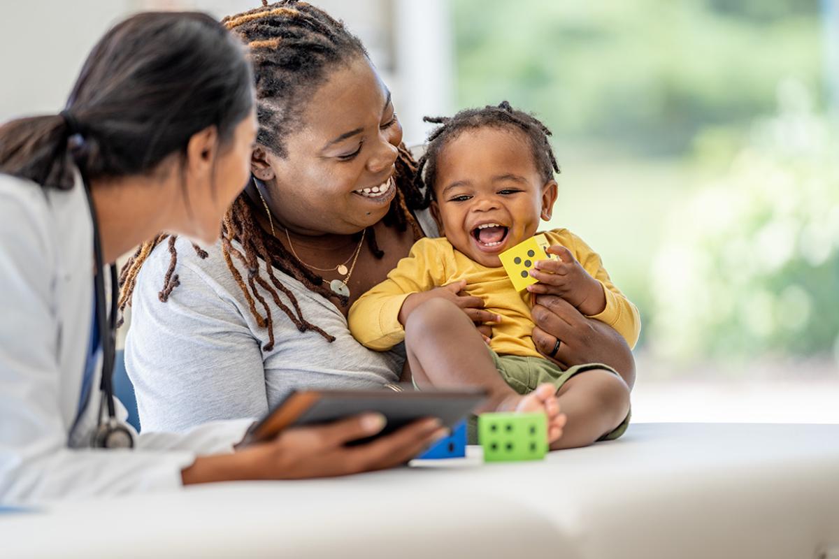 Smiling baby and mother with a physician