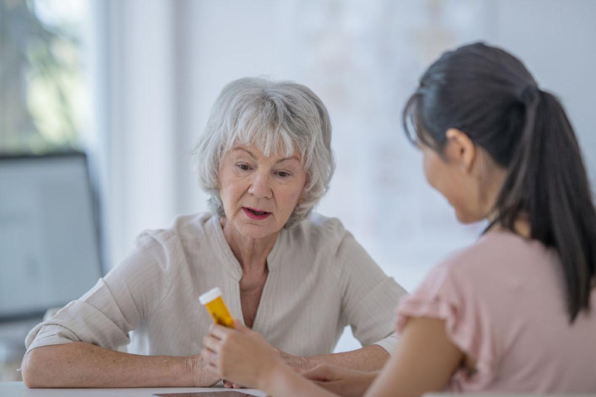 Doctor shows patient a prescription bottle