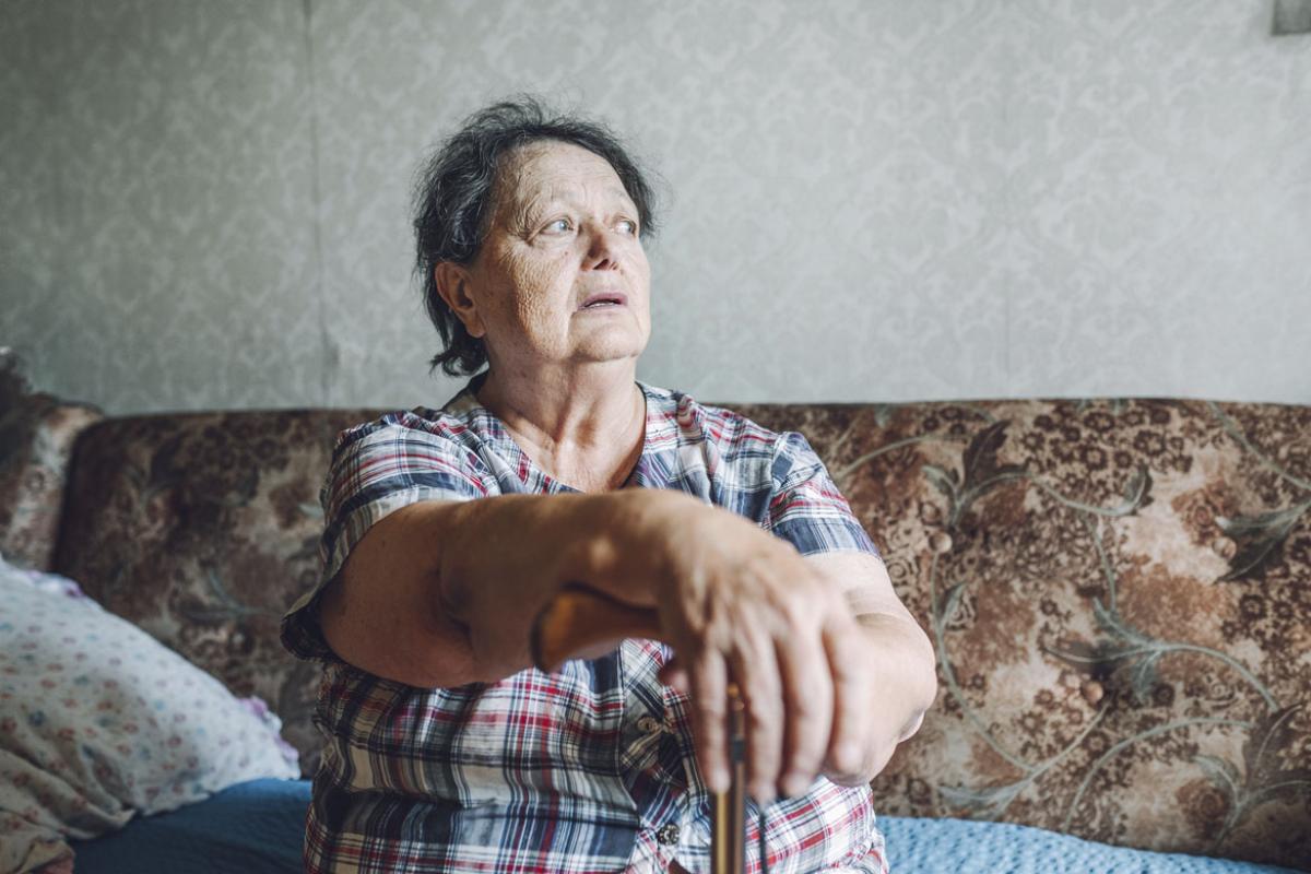 Senior woman leaning on walking cane