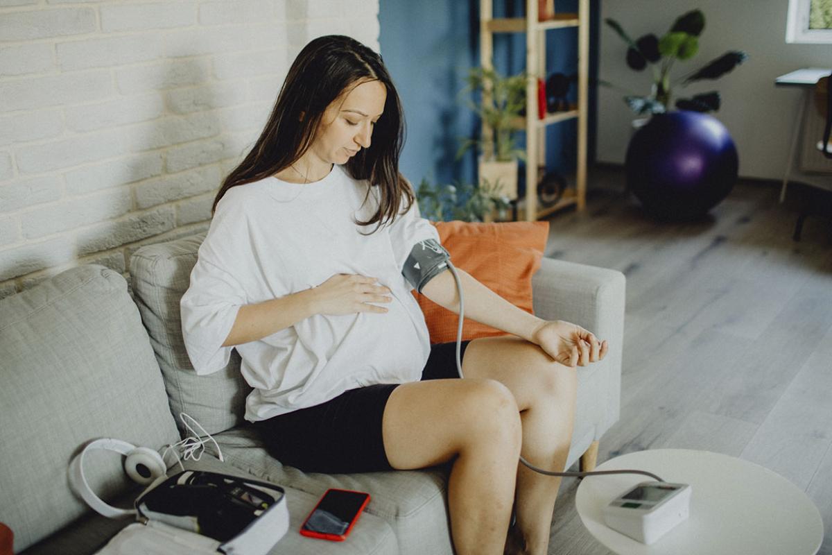 Pregnant woman checks blood pressure