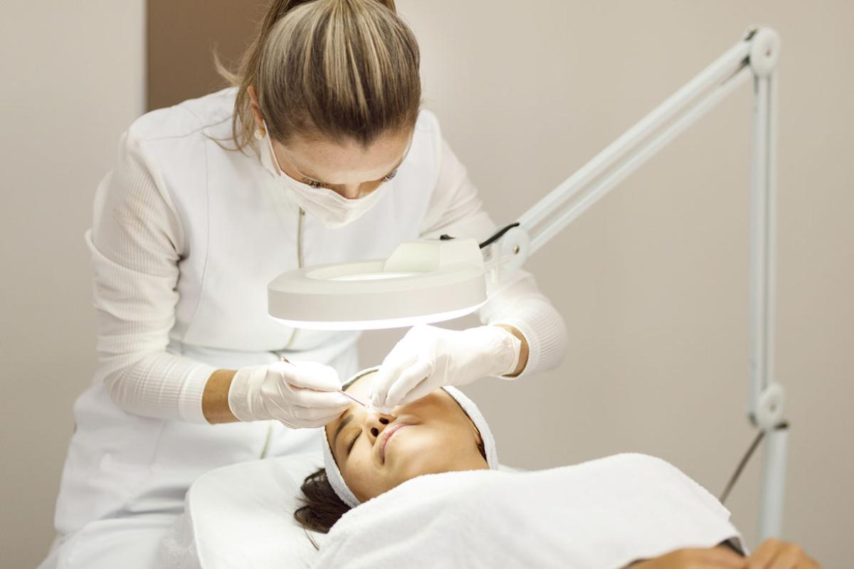 Dermatologist examining a woman's face 