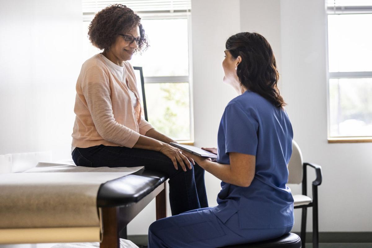 Doctor and patient conversing in doctors office
