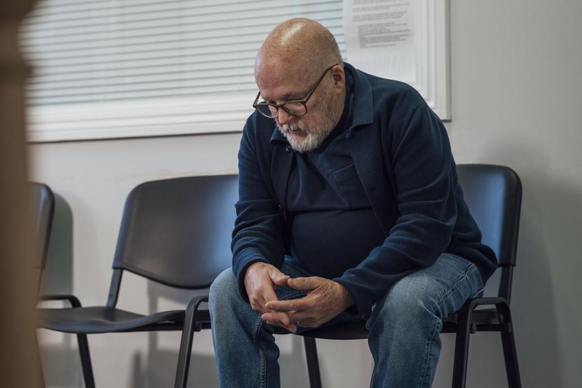 Sullen man sits in waiting room chair