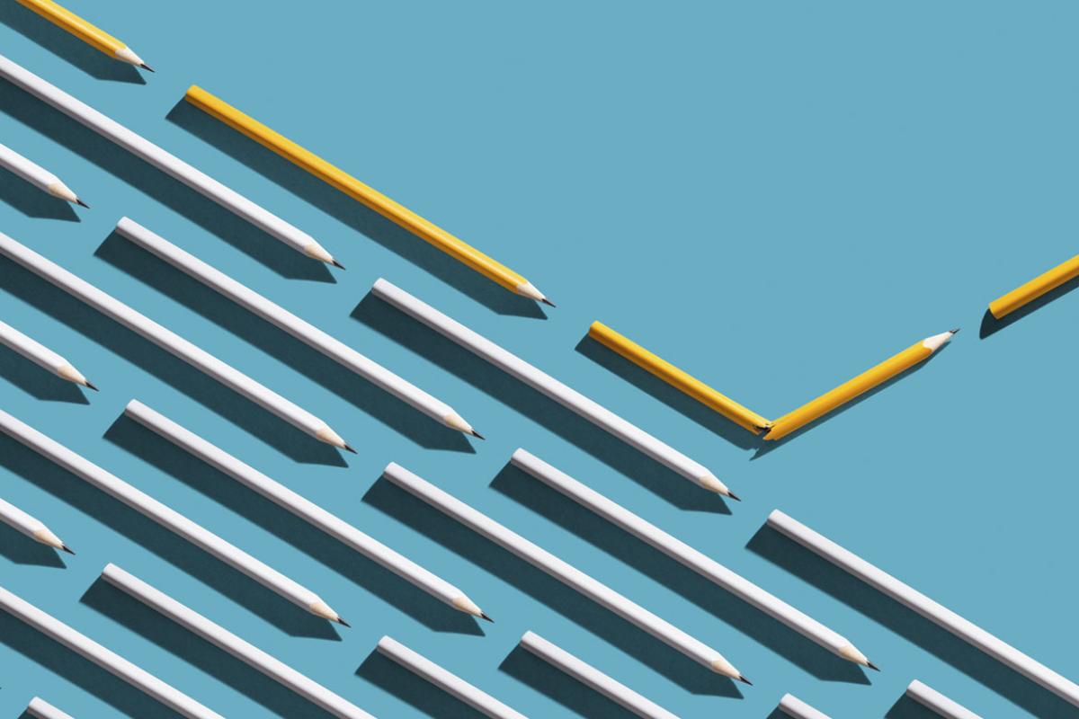 Rows of pencils, with one row moving up in a different direction