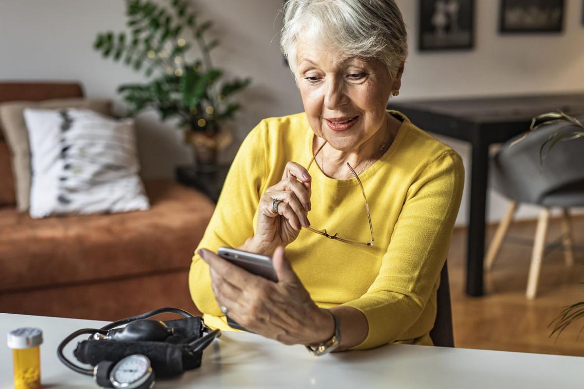 Woman holding a pill bottle and looking at smart phone