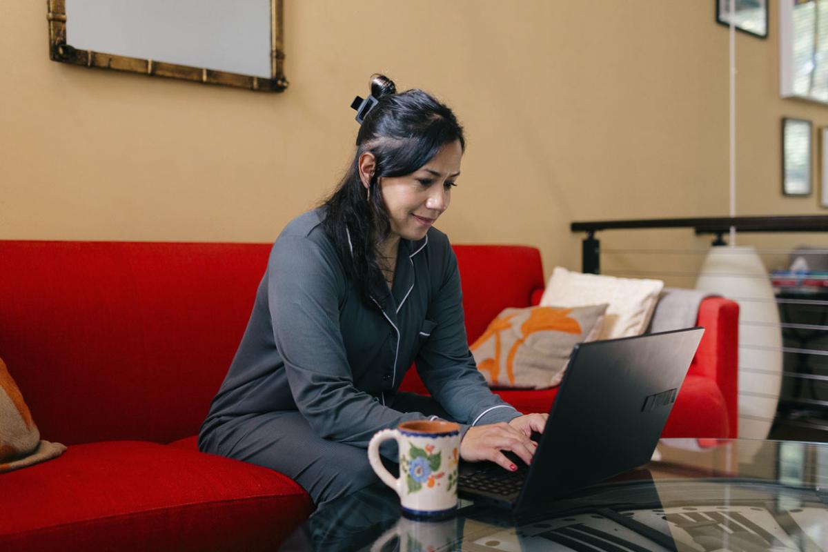 Person in pajamas works on a laptop at home