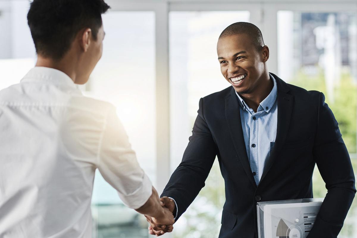 Two people shaking hands in an office setting