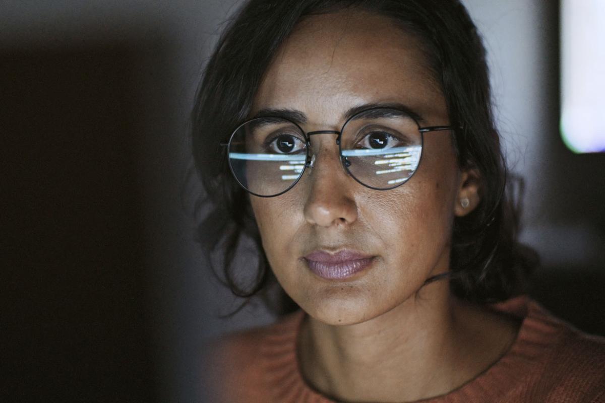 Person in glasses works at a computer