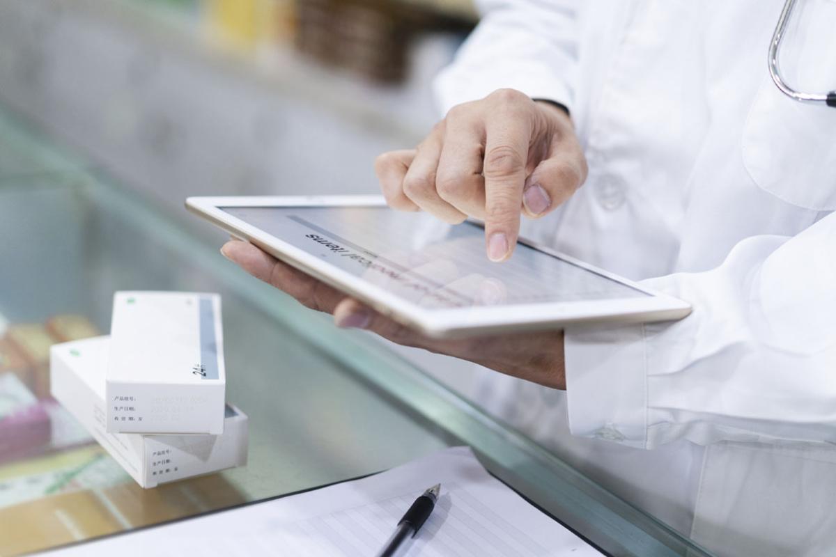 Pharmacist scrolls on a tablet