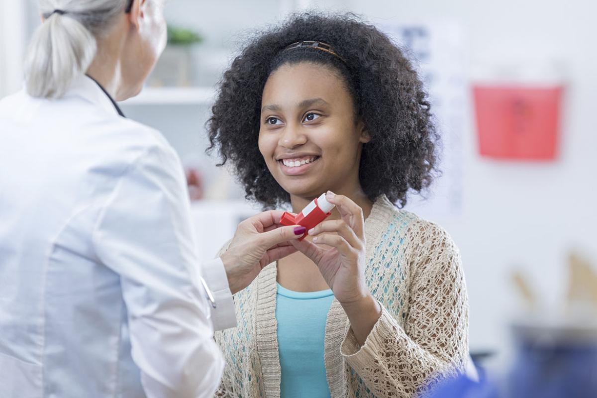 Patient holds prescription while talking to doctor
