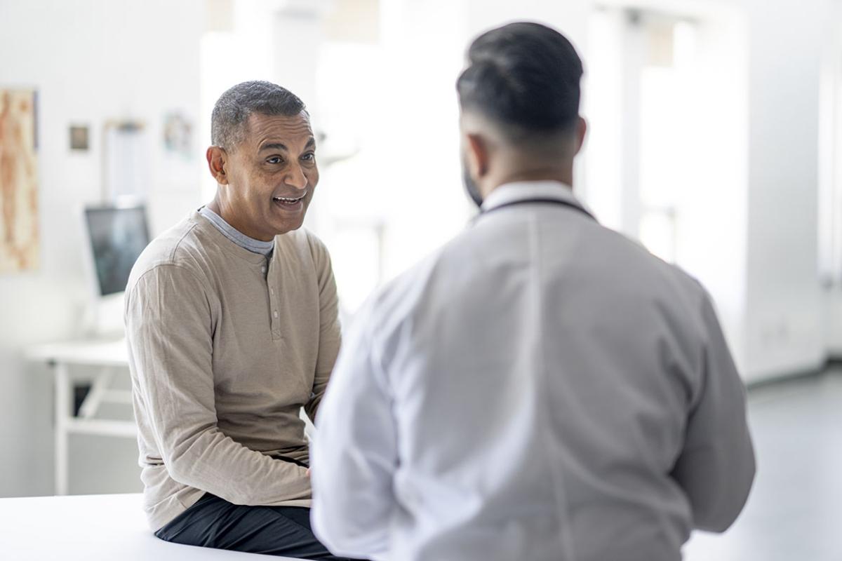 Patient on exam table in discussion with physician