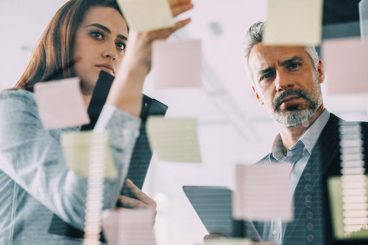 Two co-workers looking at sticky notes