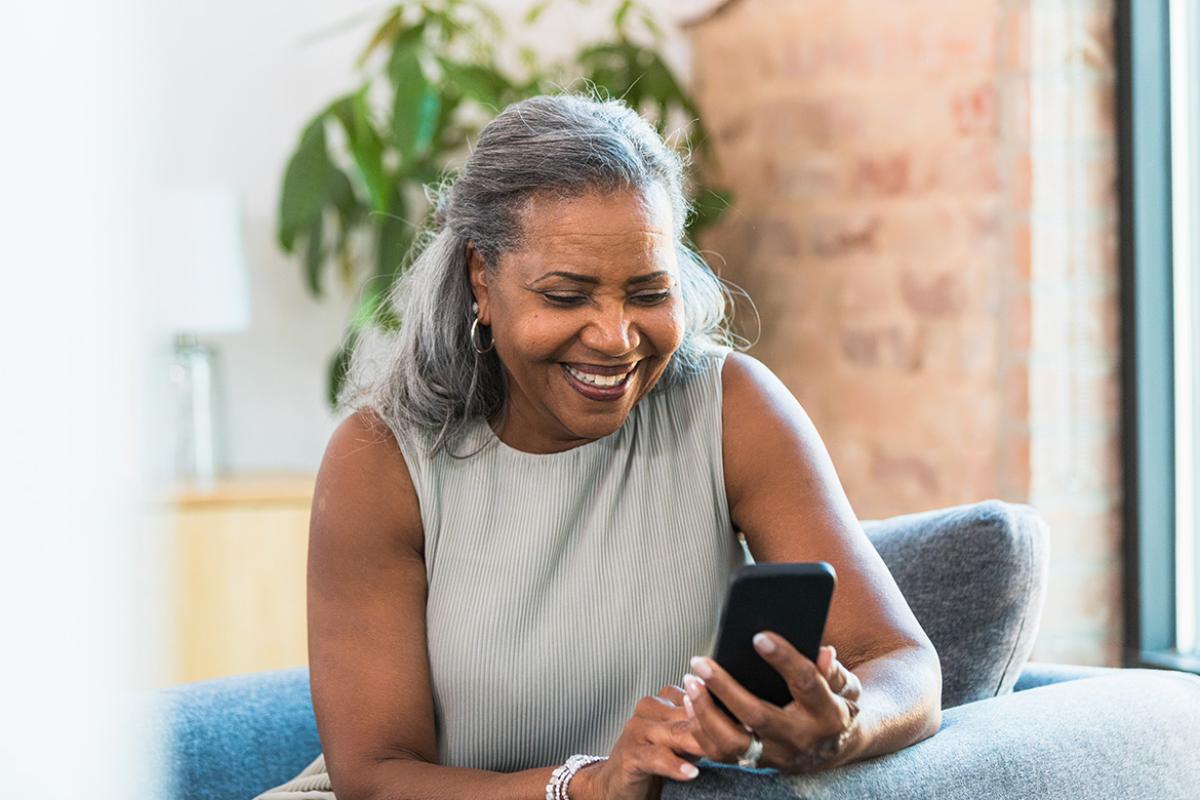 Smiling person looks at cell phone