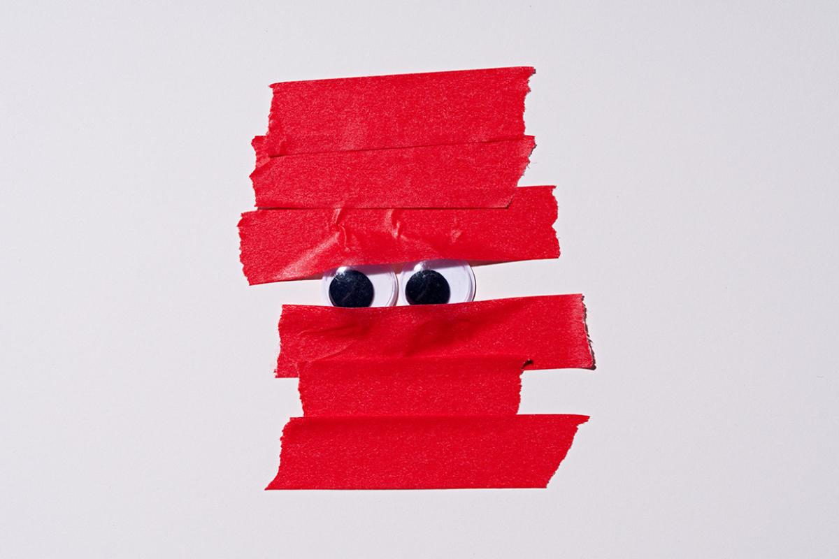 Googly eyes covered by red tape