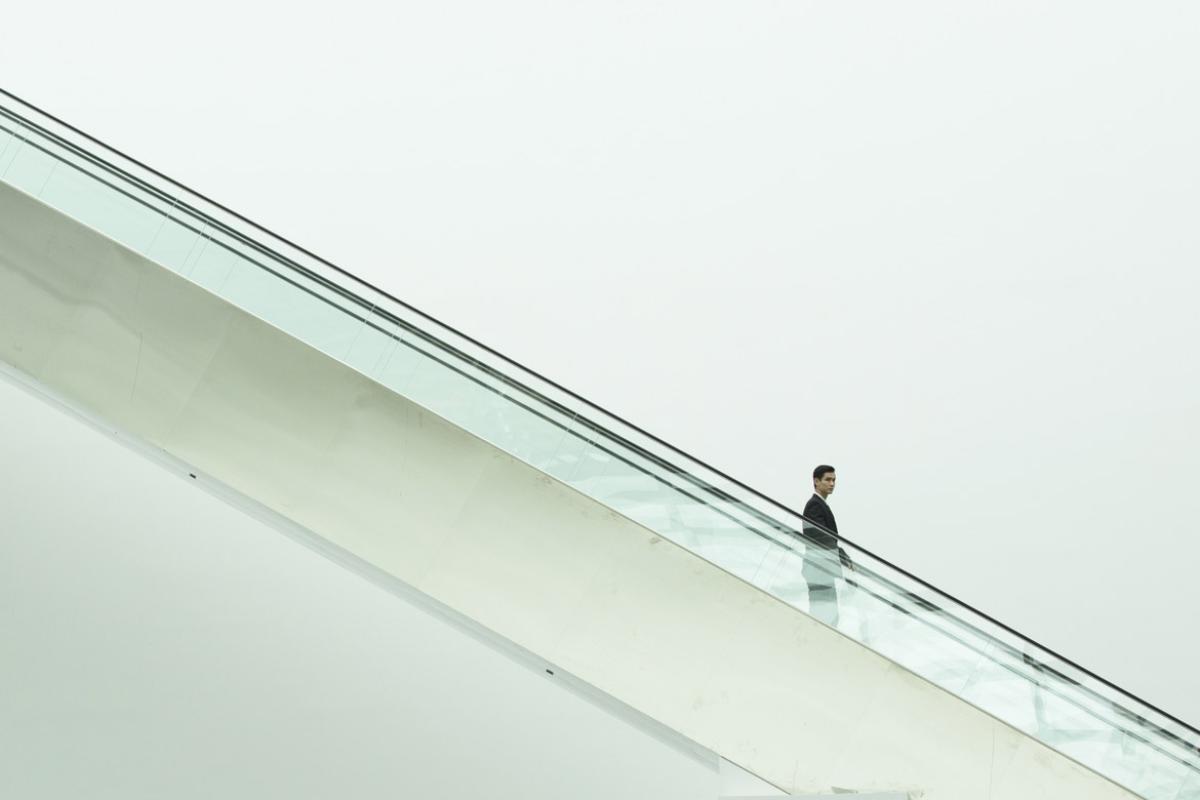 Businessperson going down an escalator 