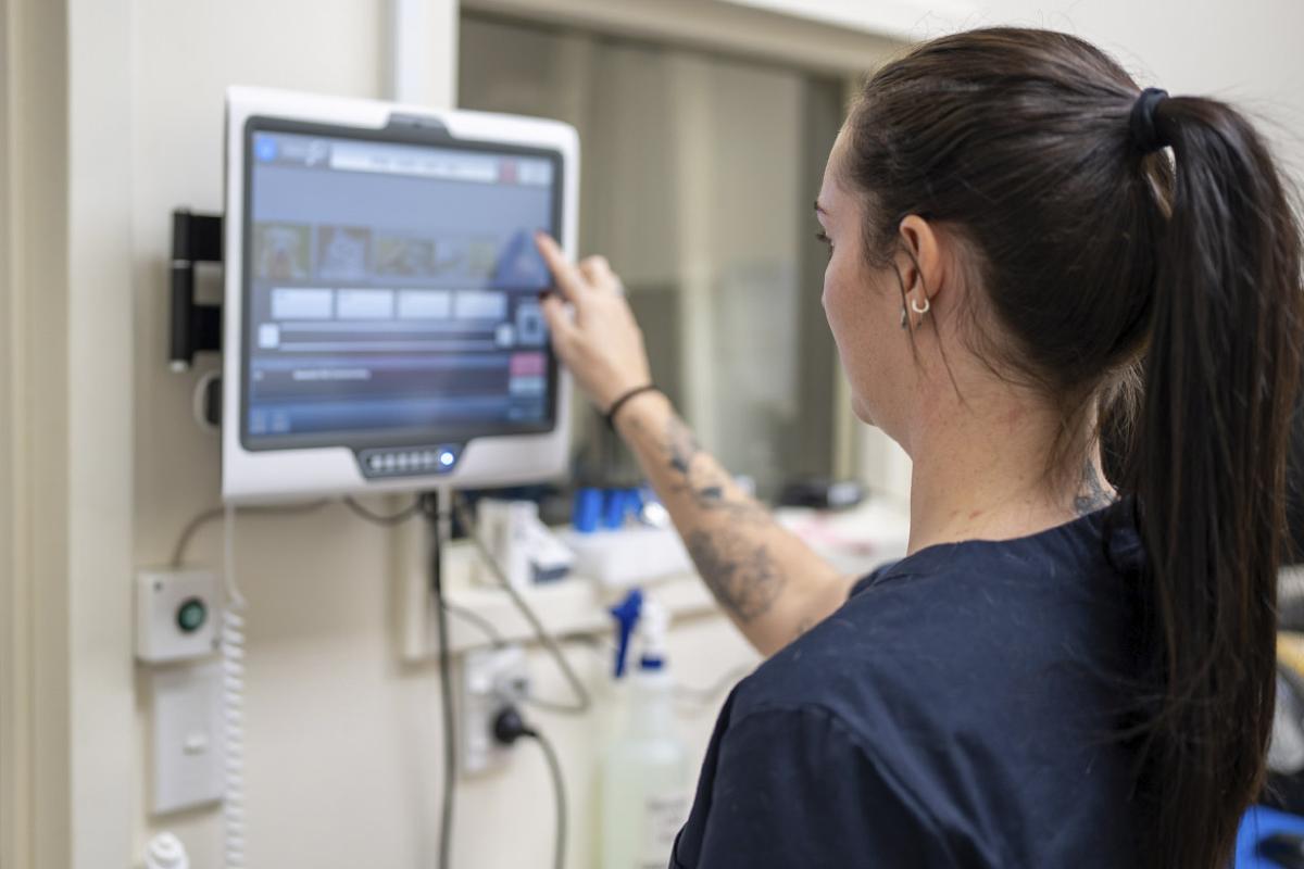 Health care worker operating a touch screen in a medical clinic