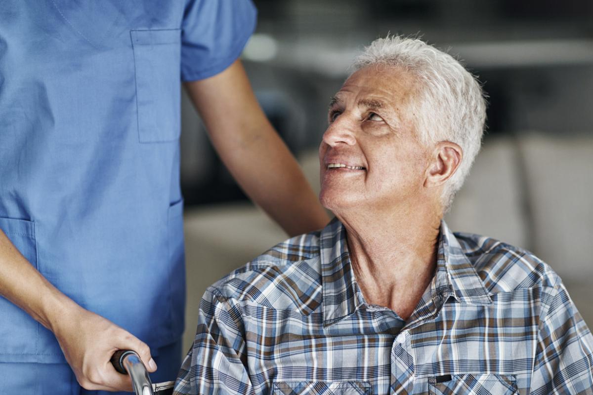 Patient in wheelchair being assisted by health care worker