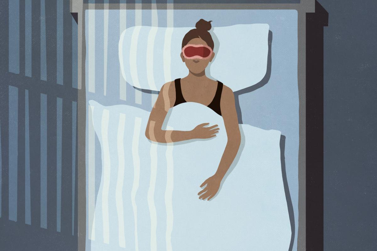 Figure with eye mask sleeping in bedroom at night