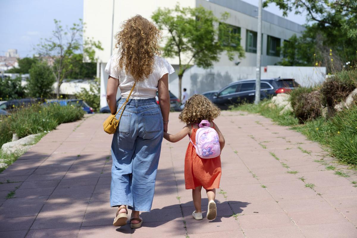Parent walks a young child to school