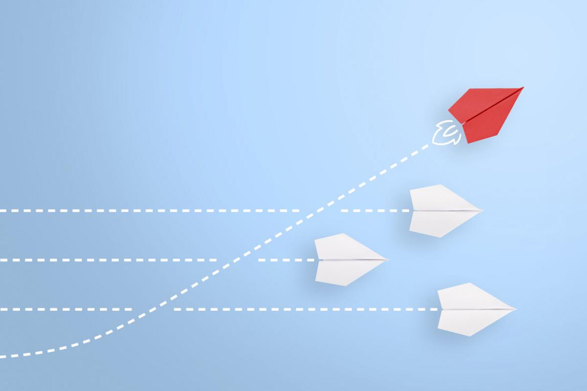 Group of paper planes with one diverging