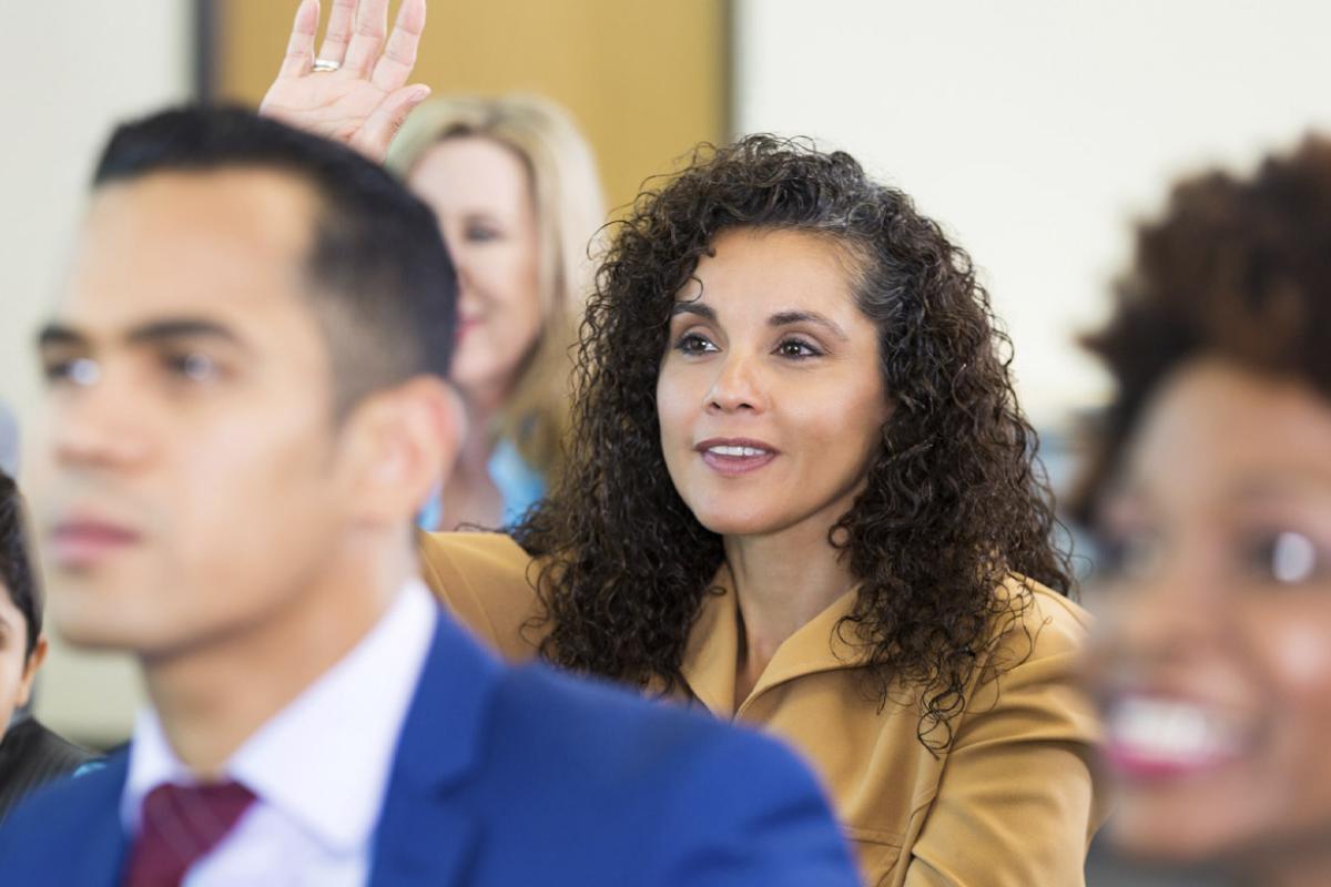 Smiling audience member with raised hand