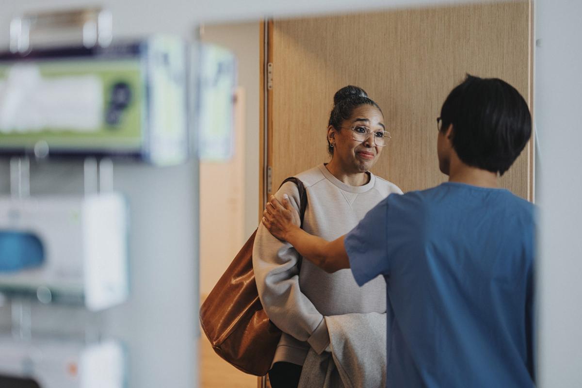 Health care worker with reassuring hand on a patient's arm