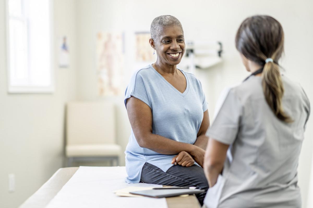 Smiling patient listens to health care worker