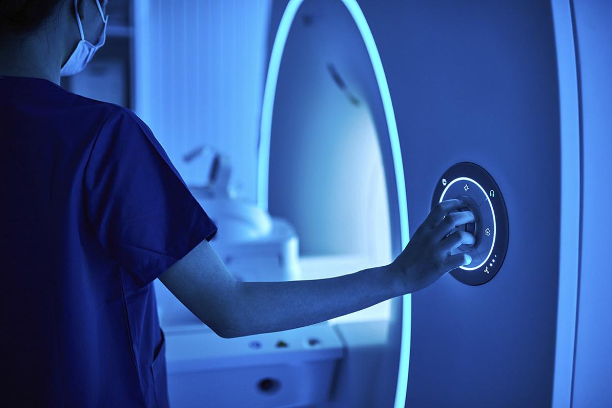 Health care worker operating MRI scan machine