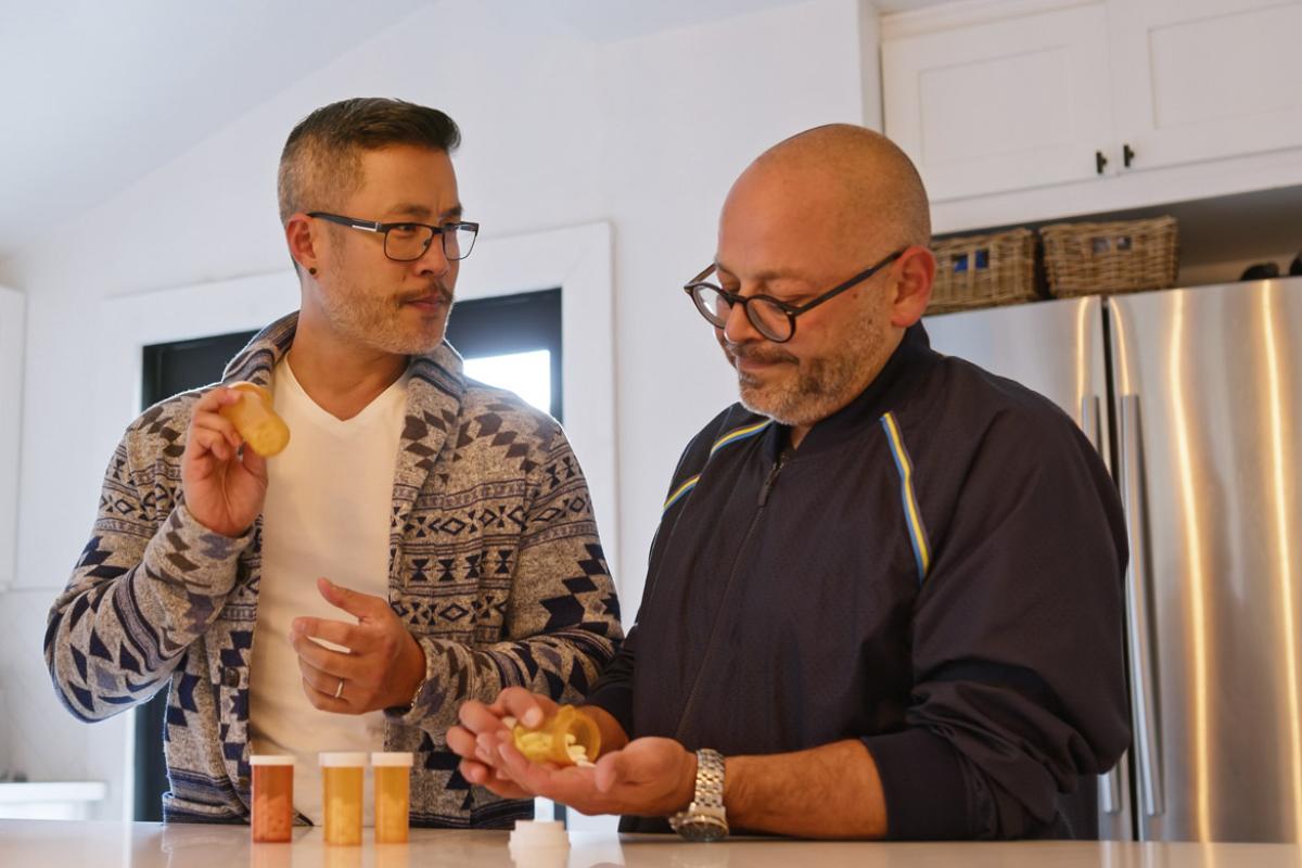 Two people check out their prescriptions in the kitchen