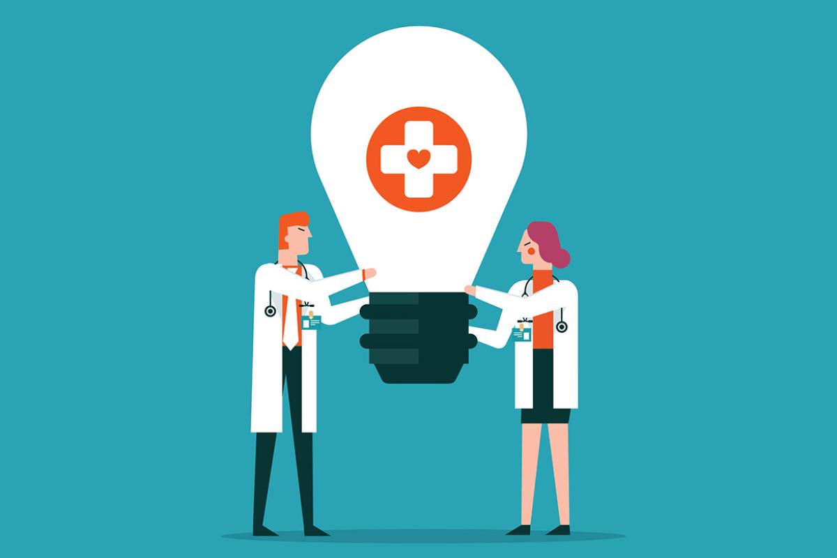Two figures hold a giant lightbulb