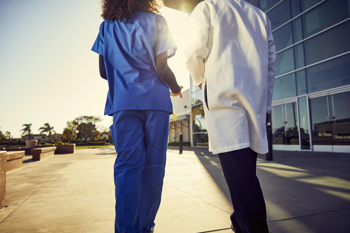 Health care workers walk outside building