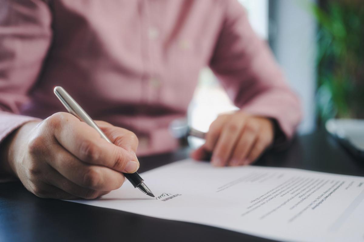 Hand signing a contract