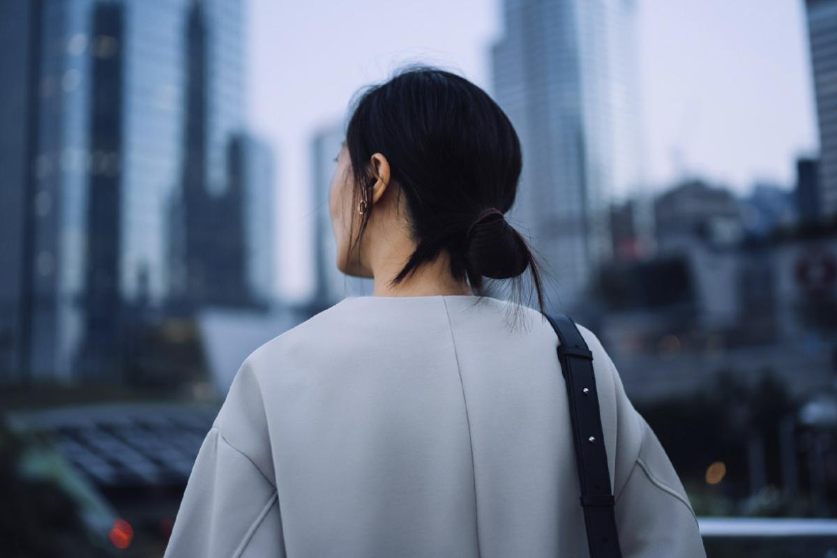 Businessperson standing against highrise corporate skyscrapers