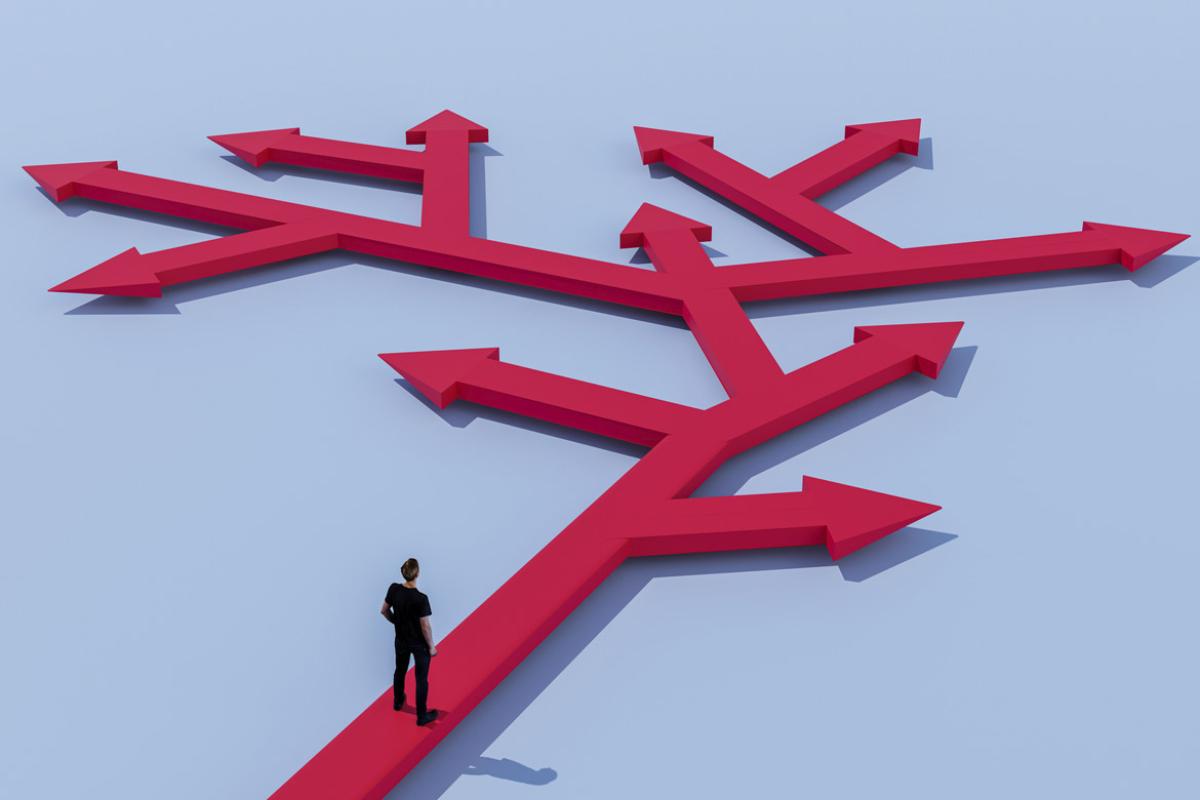 Figure stands in front of arrows pointing in different directions