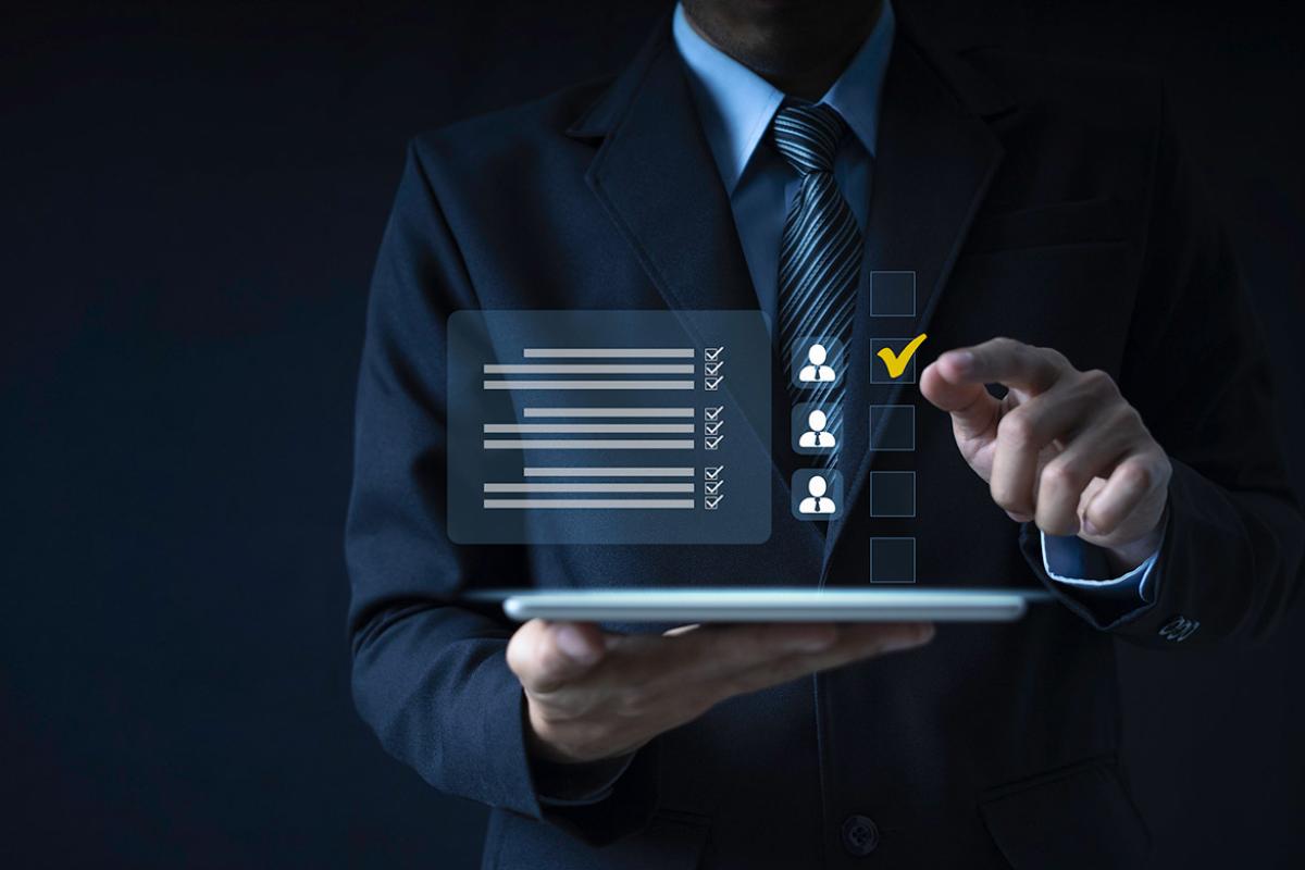 Finger points to a virtual checkbox hovered over a laptop