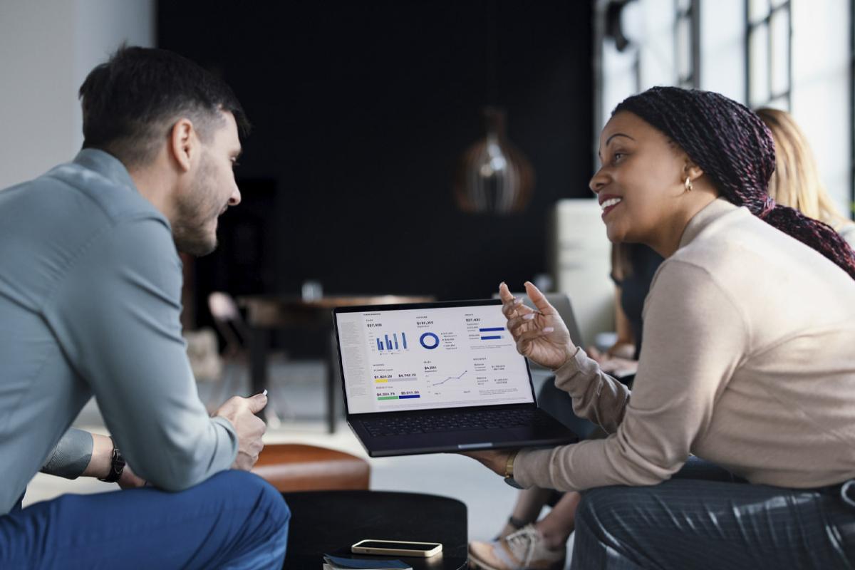 Two colleagues review data on a laptop