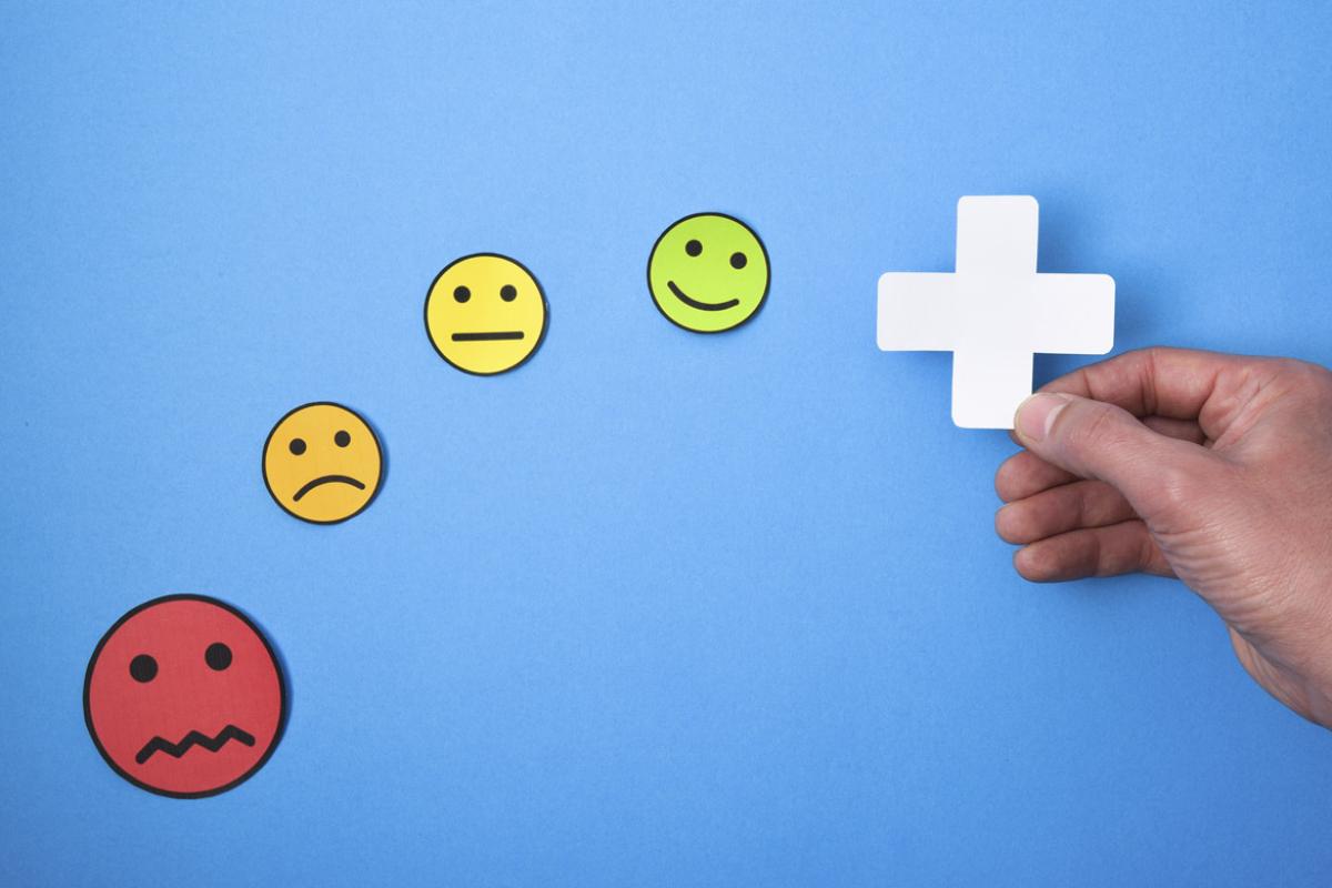 Hand holds a plus sign accompanied by emojis
