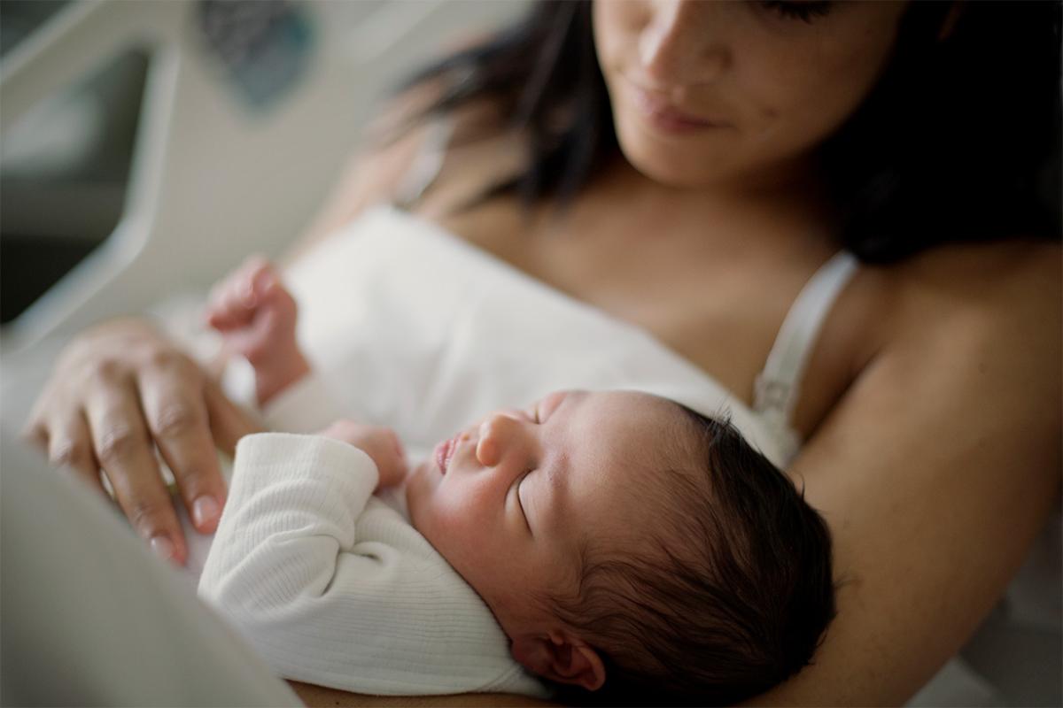 Mother cradles newborn