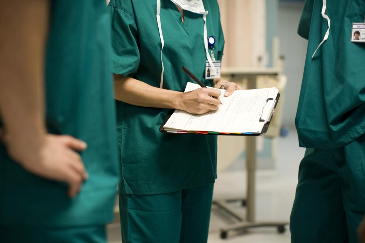 Physician writes on a clipboard